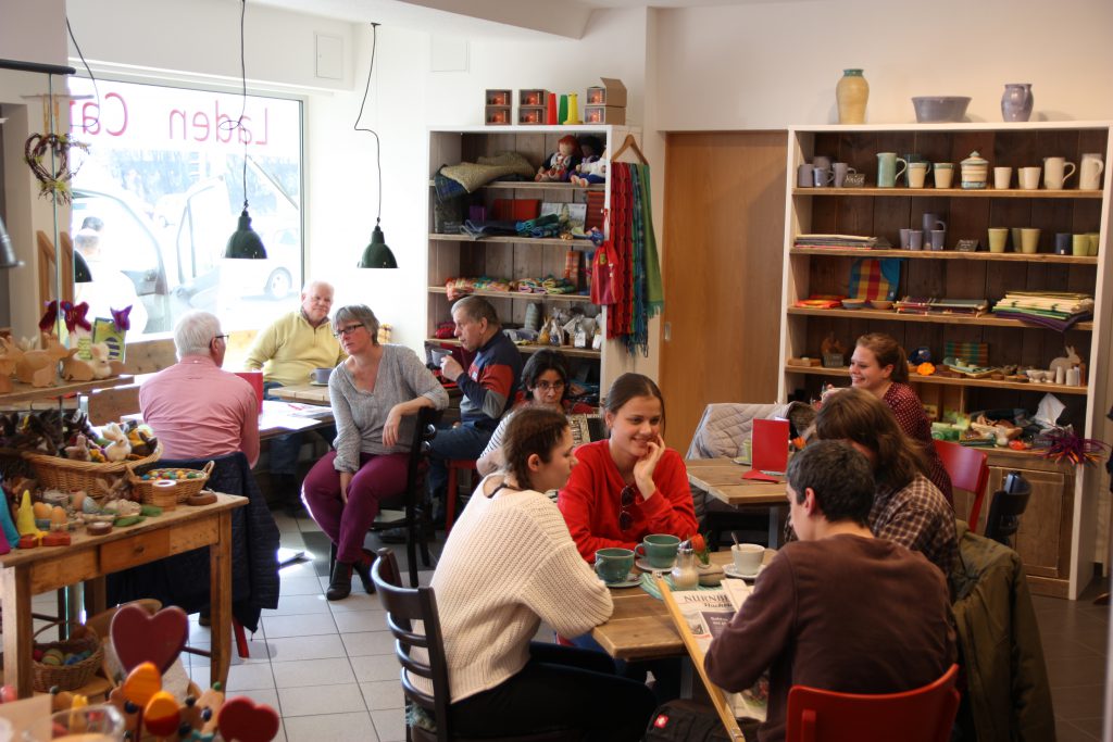 Werkstattladen und Café mit Gästen.